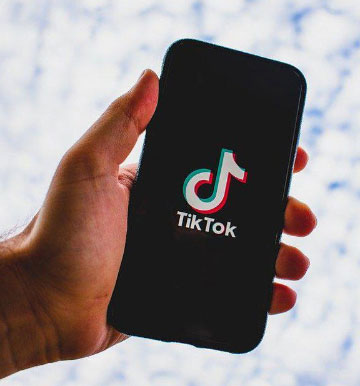 hand holding phone with ticktok logo